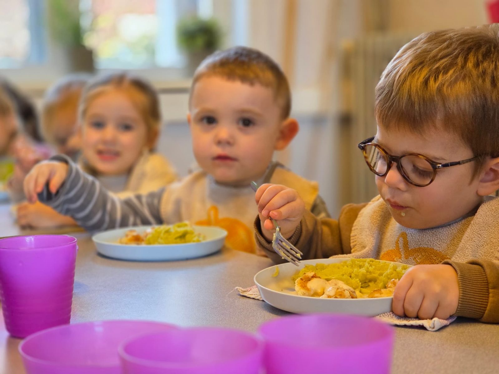 Kleuters eten samen hun warme maaltijd op school